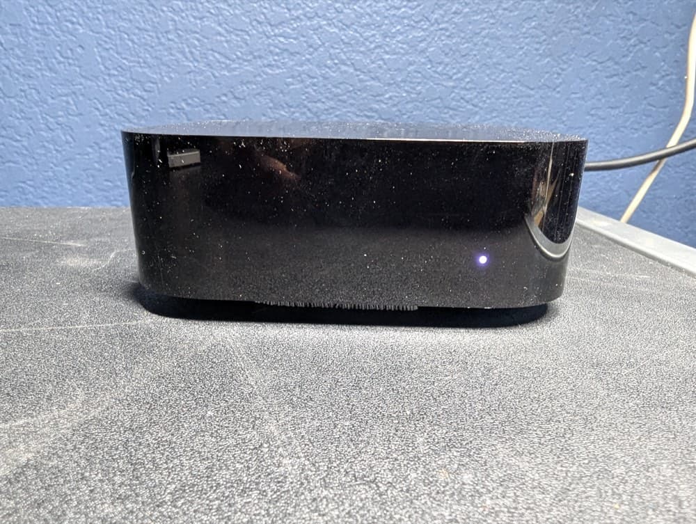 Apple TV box powered on with its status light lit