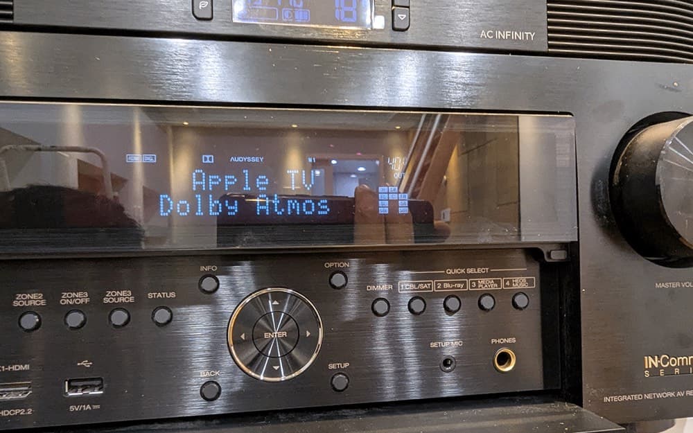 Denon receiver front panel showing Apple TV playing in Dolby Atmos